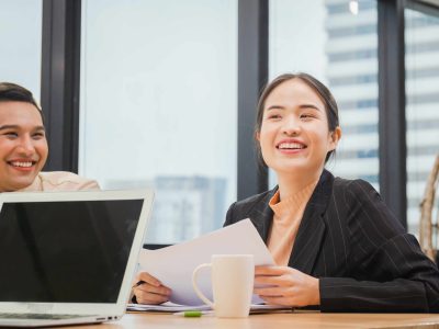 Cheerful young business partners discussing documents and ideas at meeting room, Successful and teamwork concept